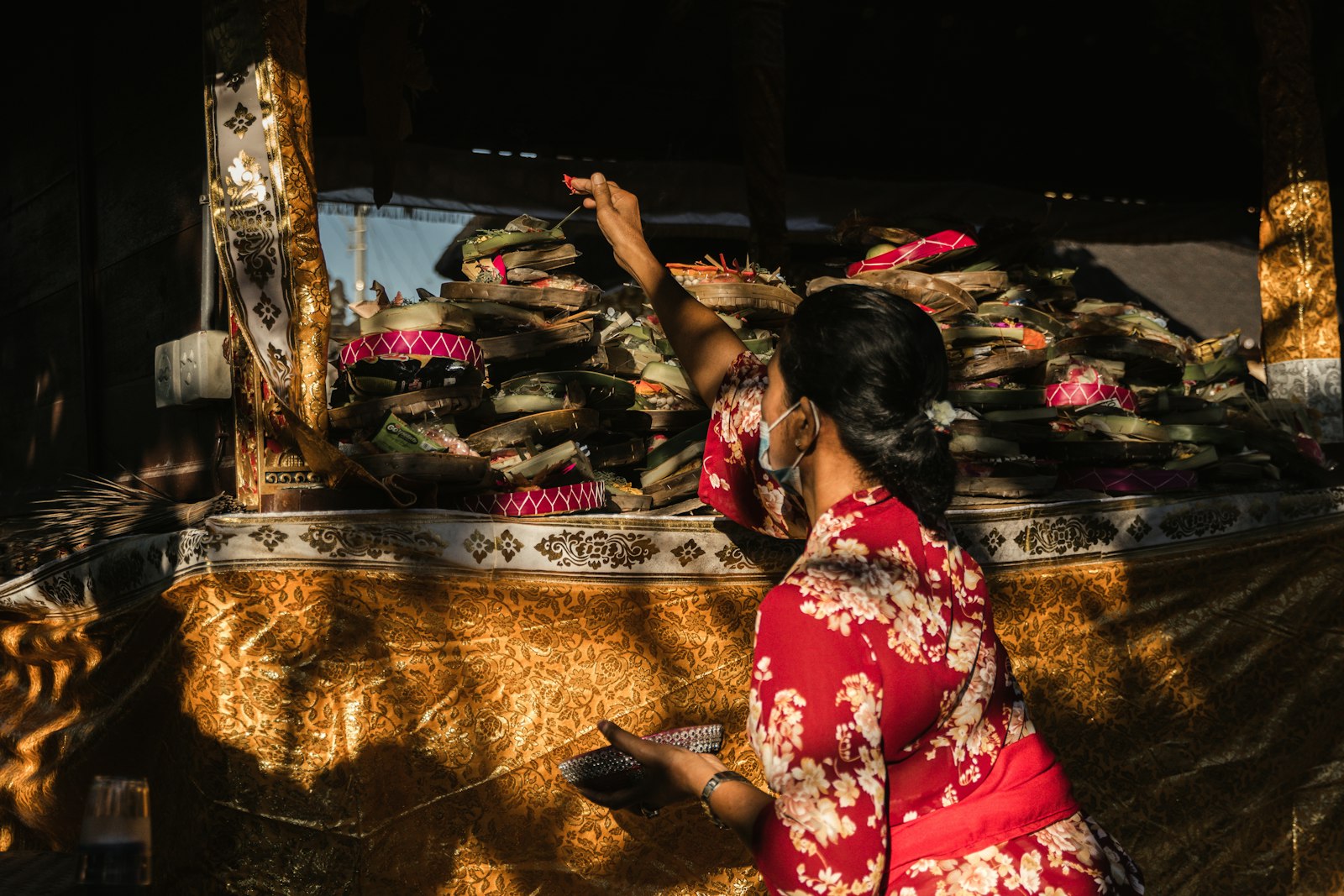 A woman beside Sumbanese cloth at a village stall